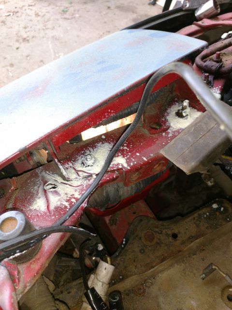 1989 Ford Probe — Engine bay of a red vehicle with wiring and white residue.