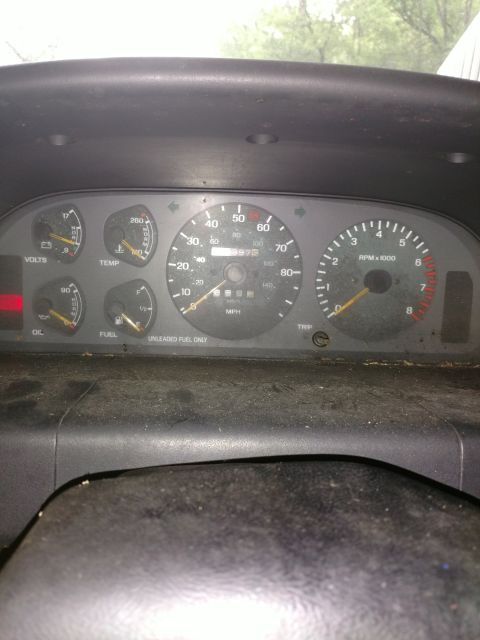 1989 Ford Probe - A close-up view of a car's dashboard gauges, including a speedometer, tachometer, fuel gauge, temperature gauge, and voltage meter. The odo…