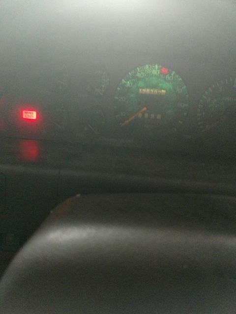 1989 Ford Probe - The image shows a close-up of a car's dashboard with the brake warning light illuminated. The odometer displays 136397 miles and the speedo…