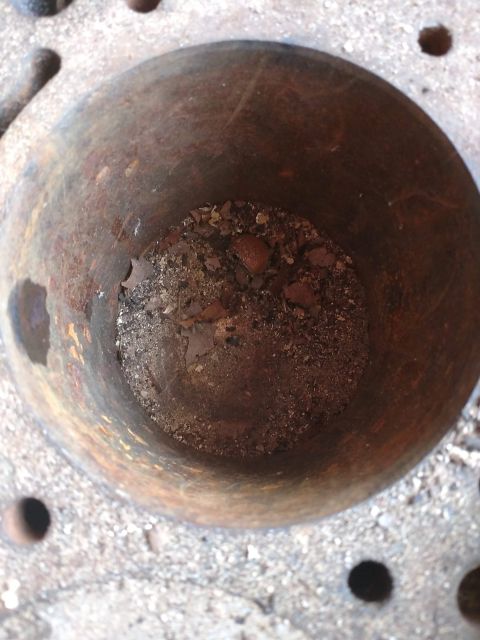 1989 Ford Probe - This is a close-up shot looking down into a rusty, cylindrical object that appears to be a mortar or a similar container. The bottom of the…