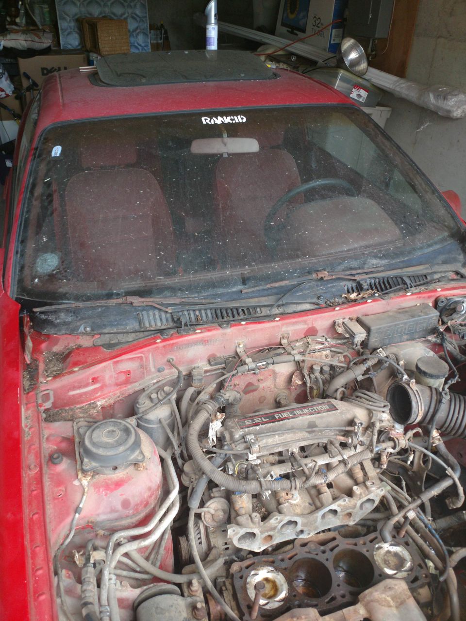Red 1989 Ford Probe engine bay with partially disassembled engine.