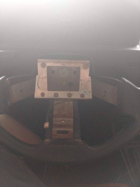 1989 Ford Probe - The image shows the steering column of a vehicle, with the steering wheel removed. A metal bracket with a circular component is visible, al…