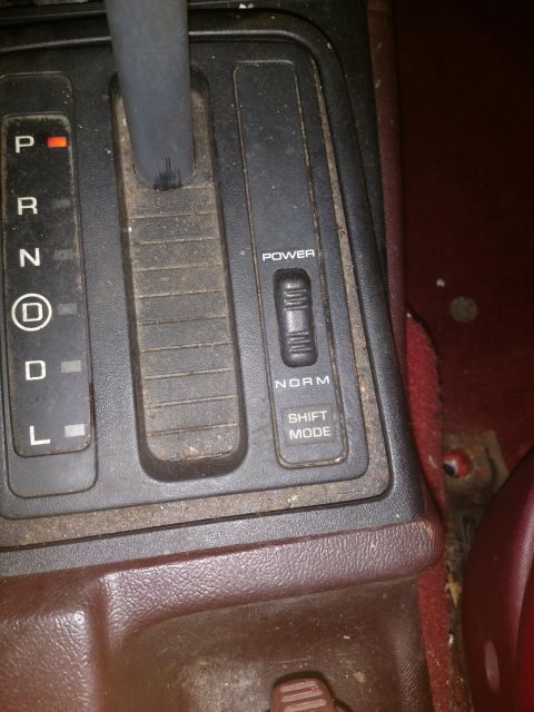 1989 Ford Probe - A close-up interior shot shows the automatic transmission shifter console of a vehicle. Visible markings include P, R, N, D, and L for gear…