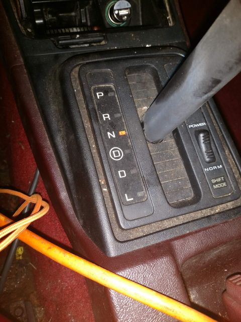 1989 Ford Probe - A close-up view of a car's automatic transmission shifter console, showing the gear selector with the indicator light on 'N' (Neutral) and…
