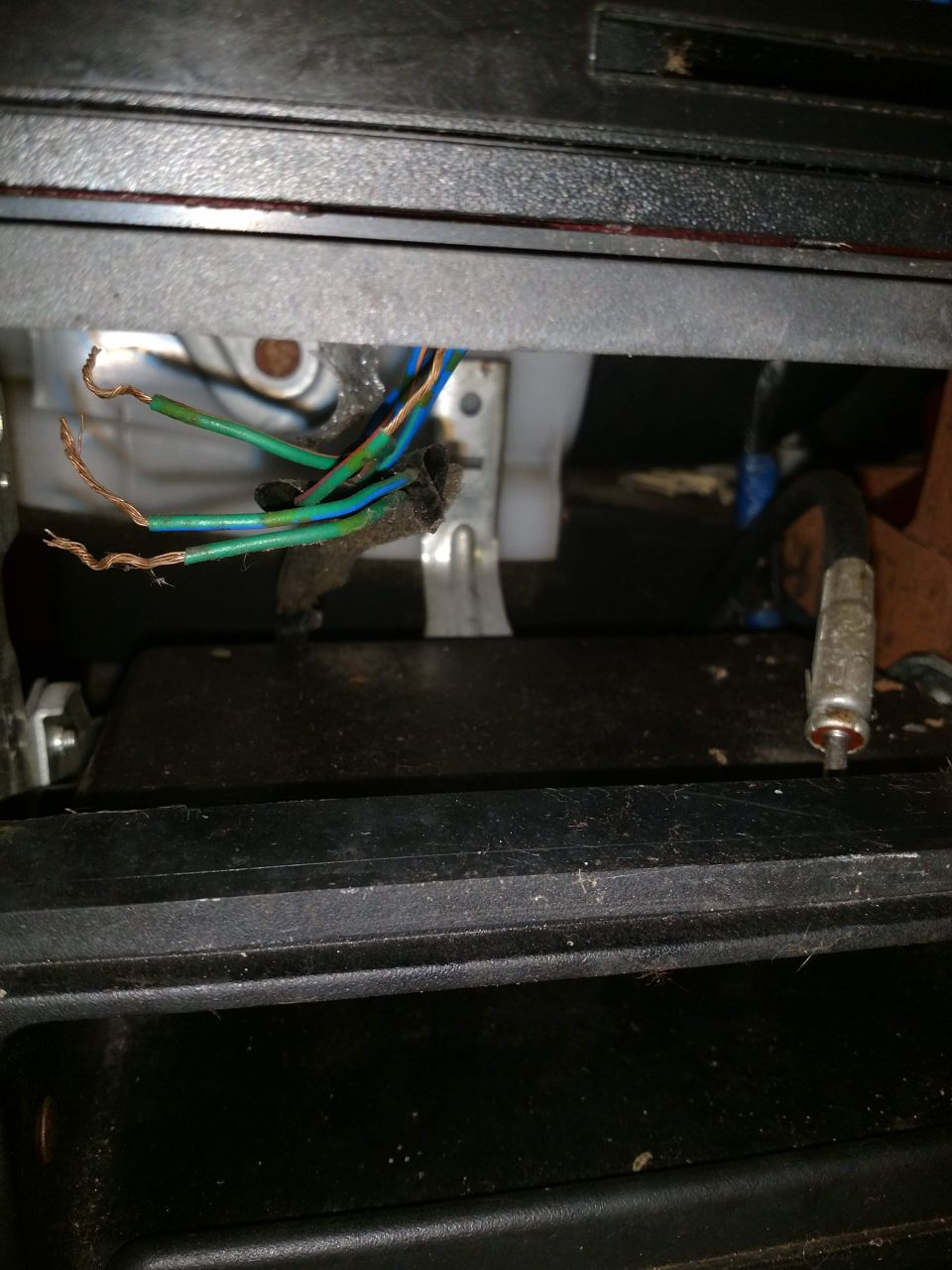 Exposed wires with green and blue insulation and a metal connector.