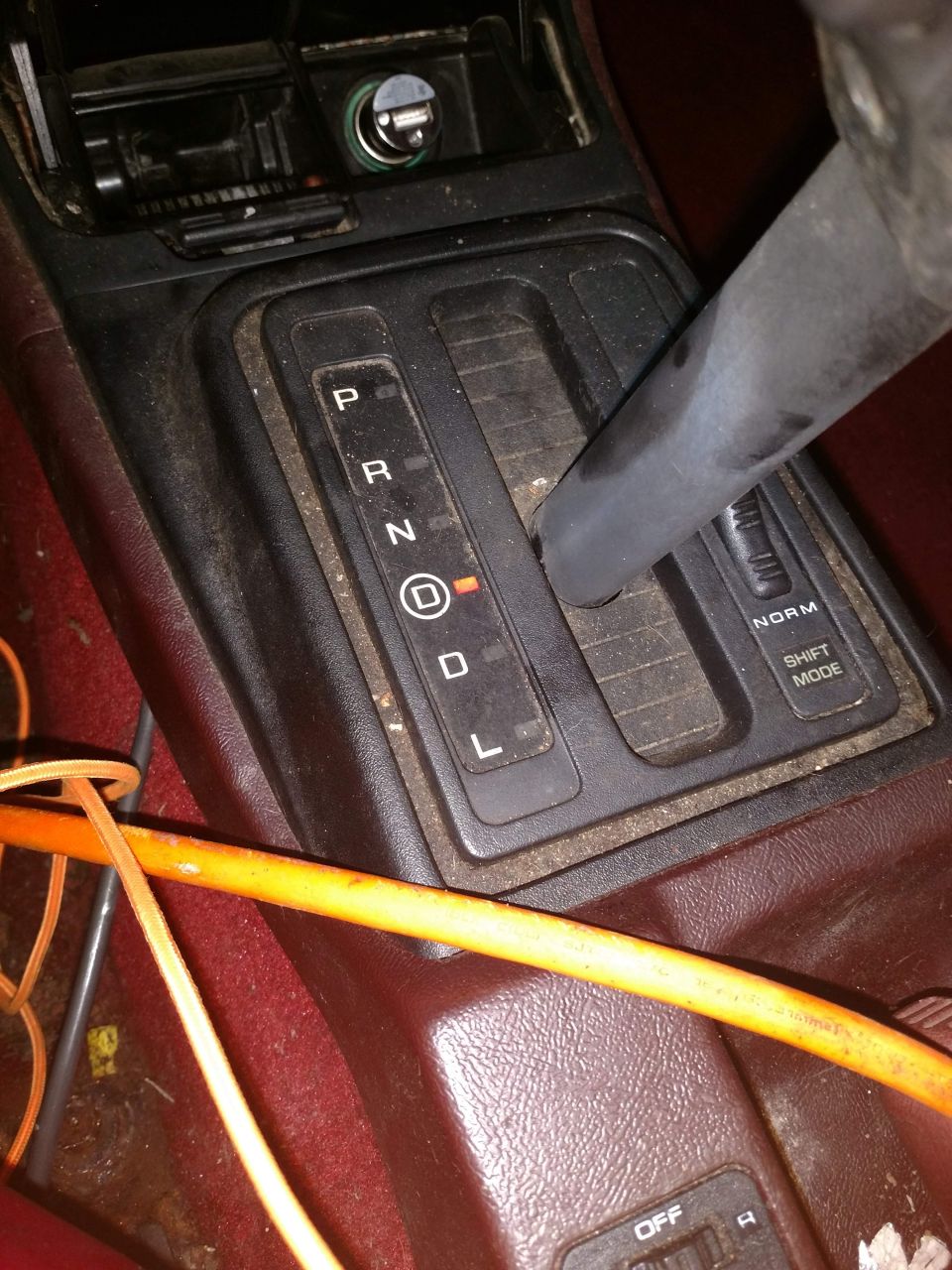 Close-up of a car's automatic gear shifter console, showing P, R, N, D, L positions with D illuminated.