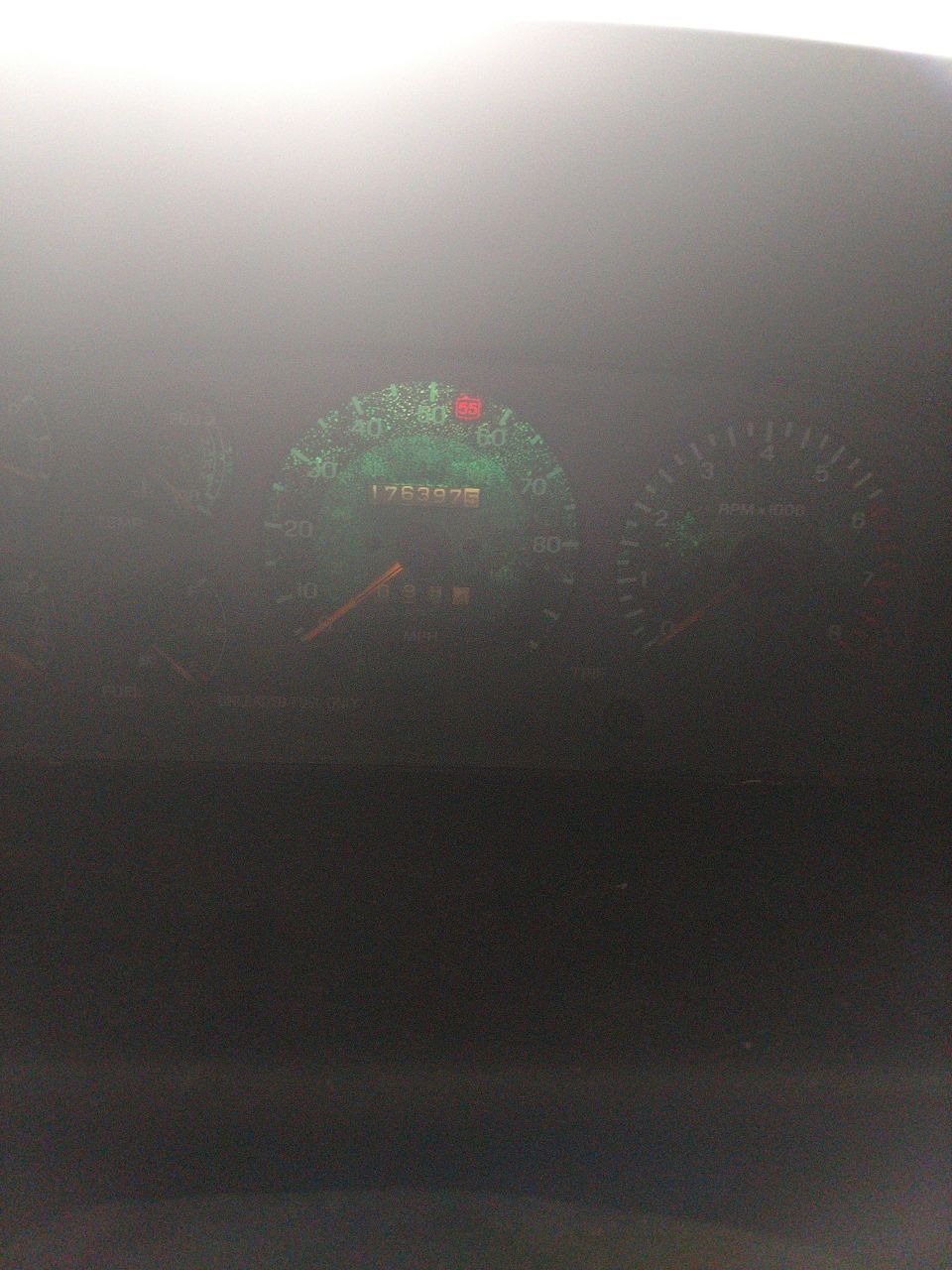 Car dashboard with speedometer showing 176397 miles and tachometer.