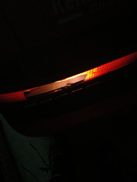 1989 Ford Probe - A close-up, low-angle shot shows the illuminated interior of a car's taillight assembly. The red lens has a textured pattern, and a bright…