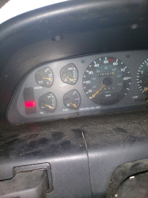 1989 Ford Probe - The dashboard of a car shows a lit red oil warning light, a voltmeter, temperature gauge, fuel gauge, and a speedometer reading 176,397 mil…
