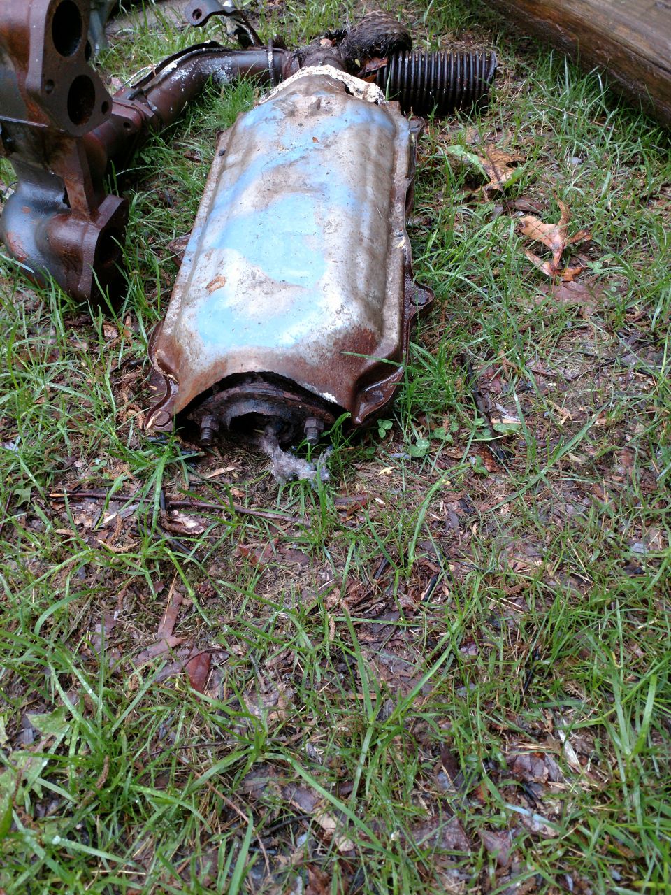 Rusted catalytic converter and exhaust manifold on the ground