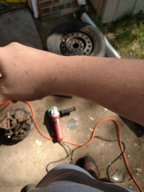 1989 Ford Probe - The image shows a person's arm and hand in the foreground, with tools and a car tire in the background. The person appears to be working on…