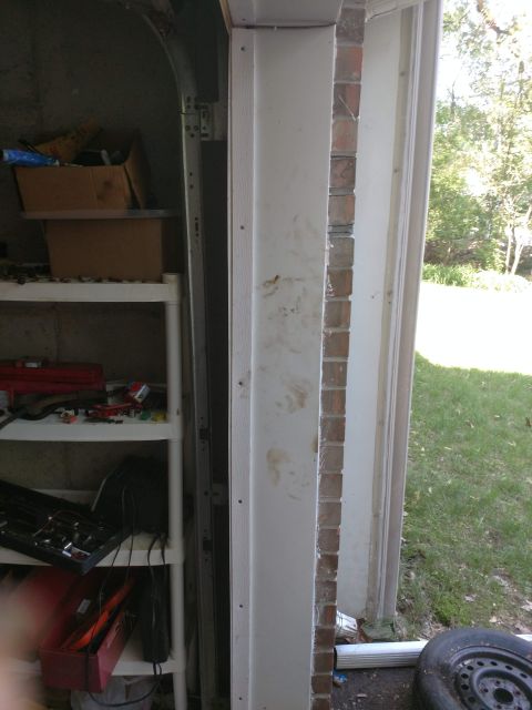 1989 Ford Probe - This image shows a cluttered garage with shelves full of items, a partially visible garage door track, and an exterior view of a doorway wi…
