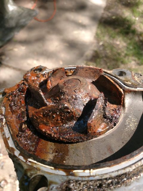 1989 Ford Probe - A heavily rusted and corroded impeller from a water pump is shown in close-up. The impeller appears to be made of metal and is covered in d…