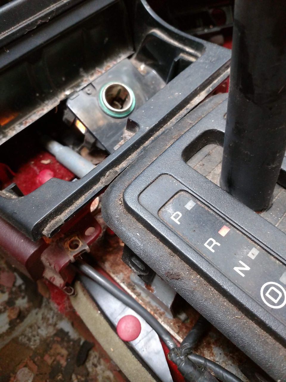 Car interior center console with gear shifter and cigarette lighter socket.
