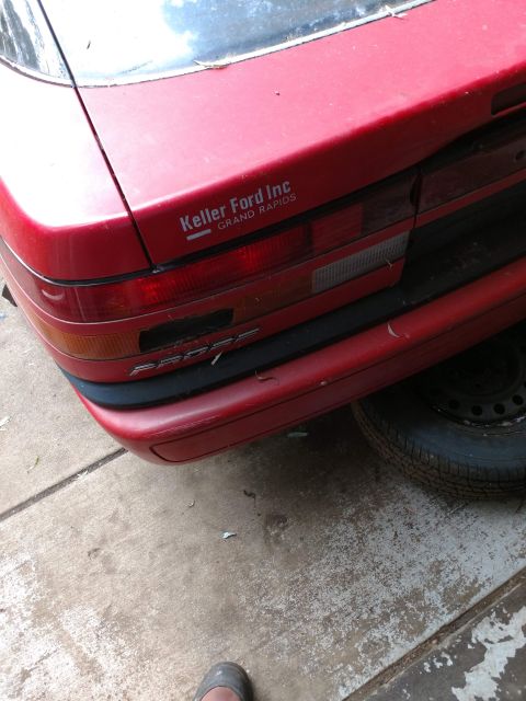 1989 Ford Probe - Rear view of a red car, showing the PROBE model name and a Keller Ford Inc. sticker.