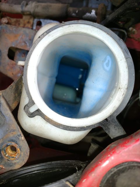 1989 Ford Probe - The coolant reservoir is filled with blue fluid. The Supermotors.net logo is visible in the lower right corner.