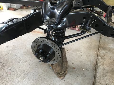 1967 Ford Galaxie - Close-up of a vehicle's front suspension system, highlighting a newly installed drilled disc brake rotor and caliper assembly.