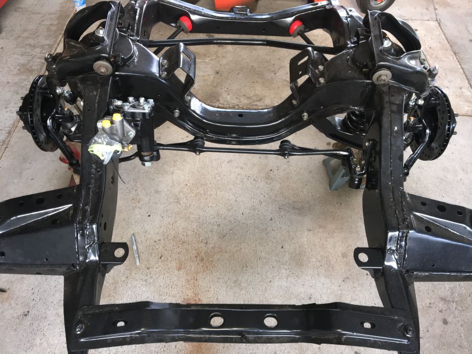 Black vehicle chassis frame with suspension components and brake lines visible