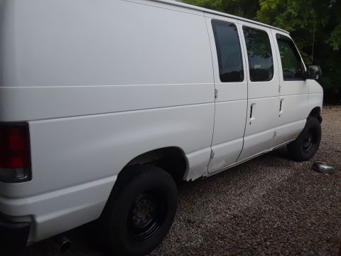 1999 Ford E250 - This white 1999 Ford E250 cargo van is shown from the side.