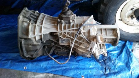 1985 Ford Bronco - A ZF transmission is shown on a blue tarp, with a tire visible to the right.
