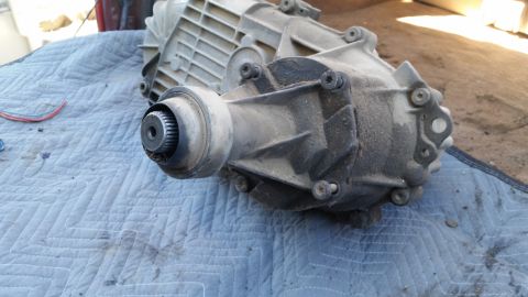 1985 Ford Bronco - A transfer case, likely from a 4WD vehicle, is shown disassembled and resting on a blue quilted mat.