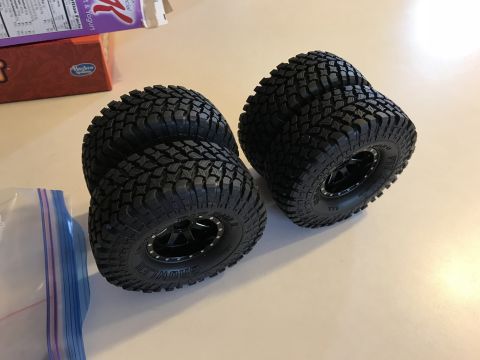1989 Ford Bronco - Four off-road tires and wheels are shown, with some packaging in the background.
