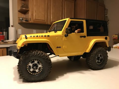 1989 Ford Bronco - A remote-controlled Jeep Wrangler, likely a Rubicon model, is shown in a three-quarter front view indoors.