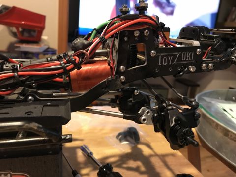1989 Ford Bronco - Close-up of an RC car chassis assembly, showing wiring, motor, and suspension components.