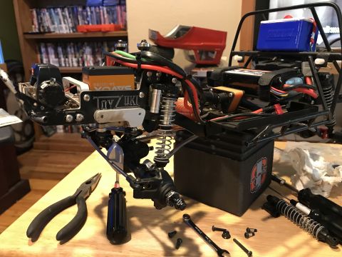 1989 Ford Bronco - RC car chassis assembly in progress, with tools and spare parts laid out.