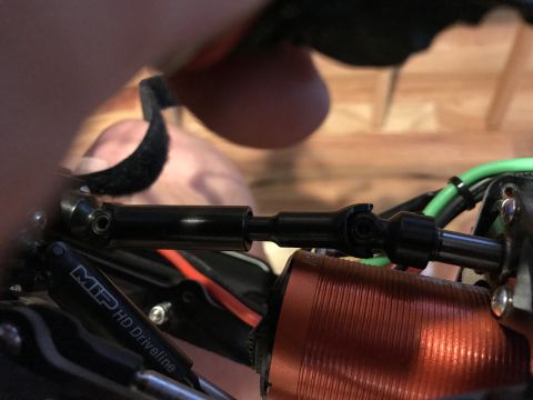 1989 Ford Bronco - Close-up of a black metal driveline part, labeled MIP HD Driveline, from an RC car.
