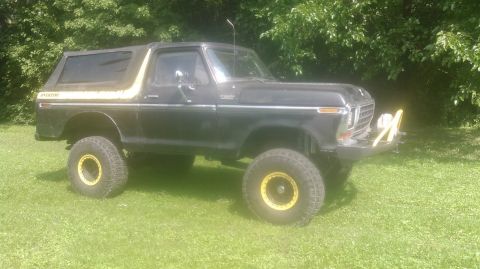 1978 Ford Bronco - This 1978 Ford Bronco features a black exterior with distinctive yellow trim and matching yellow wheels, seen parked outdoors.