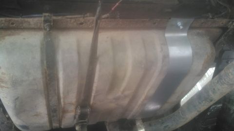 1978 Ford Bronco - Underside view of a vehicle's fuel tank, showing a replacement strap.