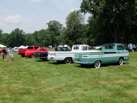 1971 Ford Ranchero - A line of classic pickup trucks are displayed on a grassy field under a partly cloudy sky.