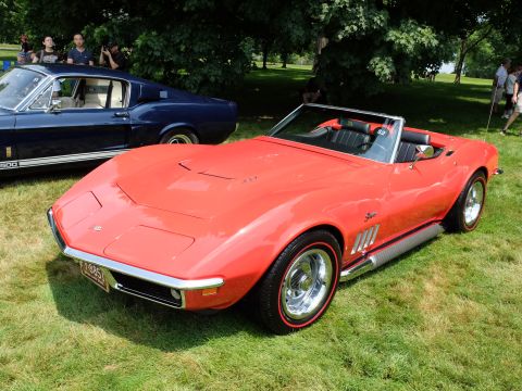 1971 Ford Ranchero - A red convertible sports car with a black interior is parked on a grassy lawn next to a blue coupe.