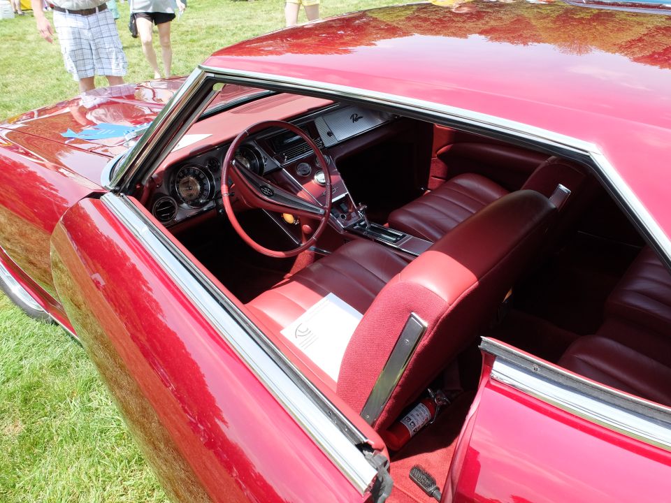 Red 1966 Buick Riviera interior with bucket seats and woodgrain dash