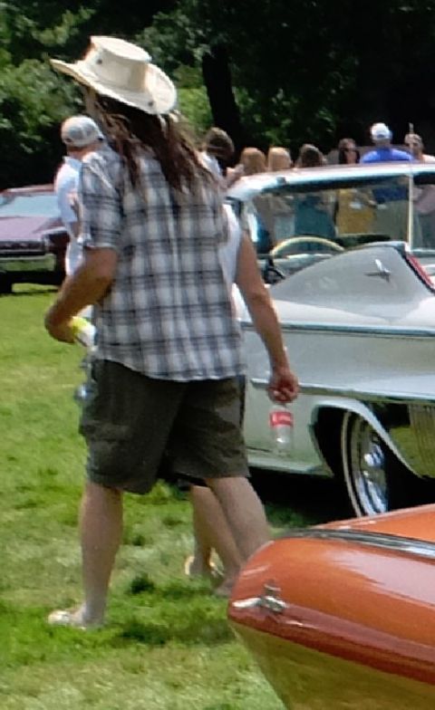 1971 Ford Ranchero - A white convertible with extensive chrome detailing is visible at an outdoor event.