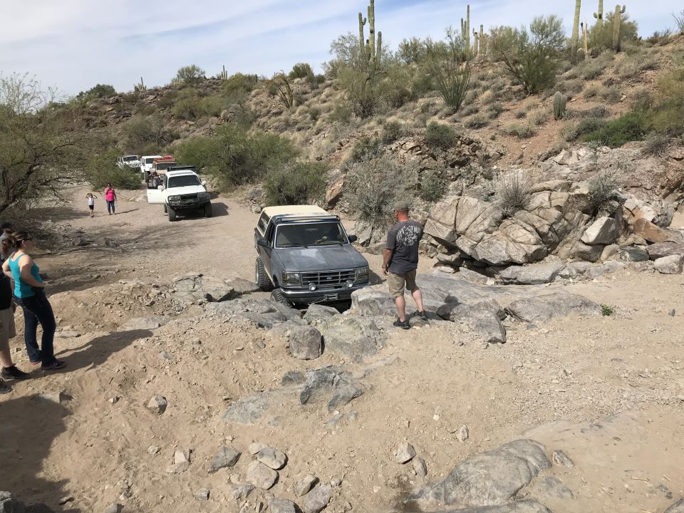Gray Ford Bronco navigating rocky terrain, front quarter view