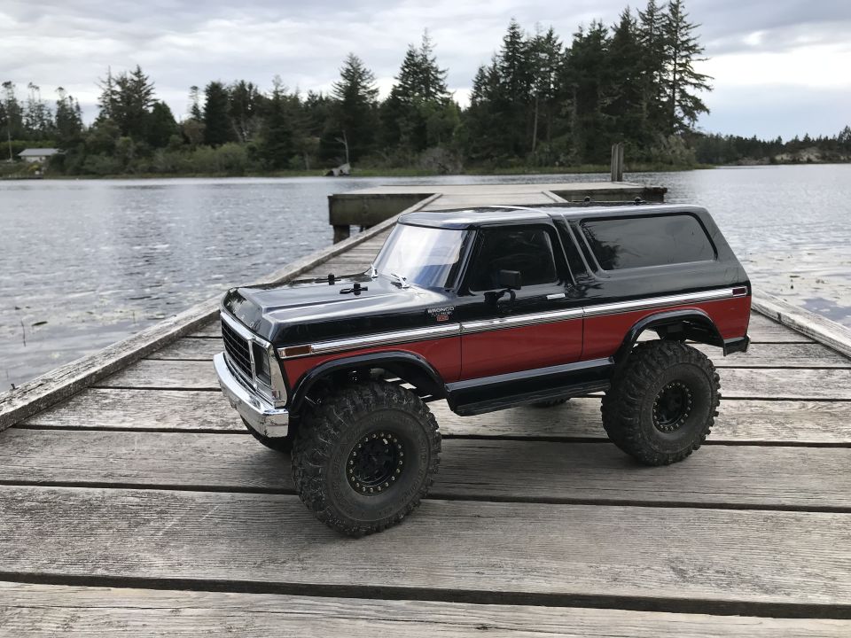 Black and red SUV with large tires on a wooden dock