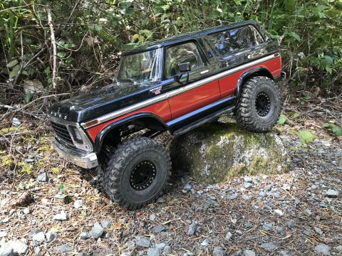 1989 Ford Bronco - RC model of a 1978-1979 Ford Bronco climbing over a rock in a wooded area.