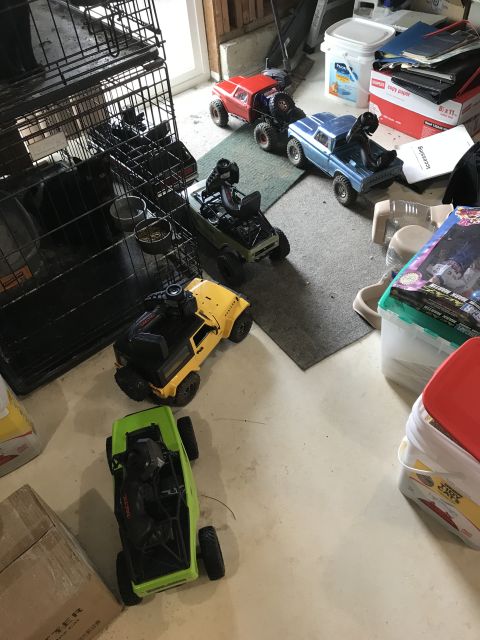 1989 Ford Bronco - Several remote control cars are visible on the floor, with a dog crate to the left and storage containers to the right.