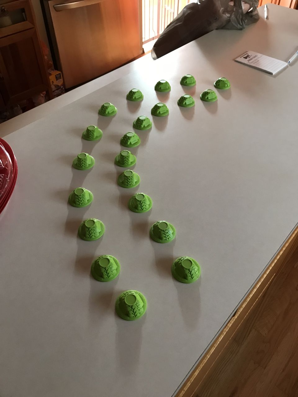 Green plastic bottle caps arranged on a kitchen counter