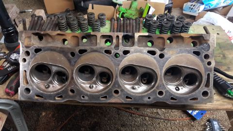 1978 Ford Bronco - Engine cylinder head with valves and springs visible, laid out on a wooden surface.