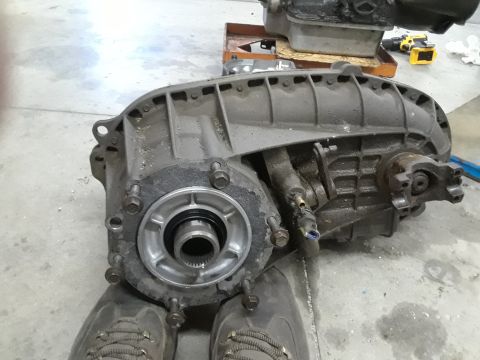 1996 Ford F-350 - A transfer case component is shown from a side angle, resting on a concrete floor.