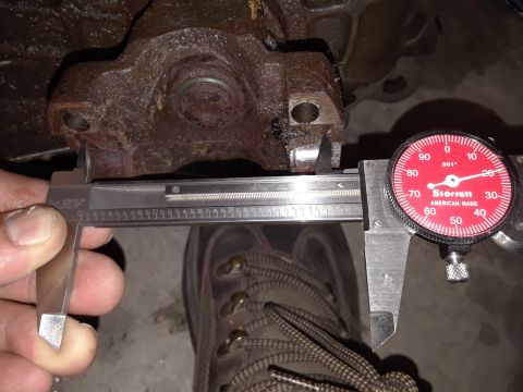 1996 Ford F-350 - A caliper measures a rusty automotive part, with a dial indicator also visible.