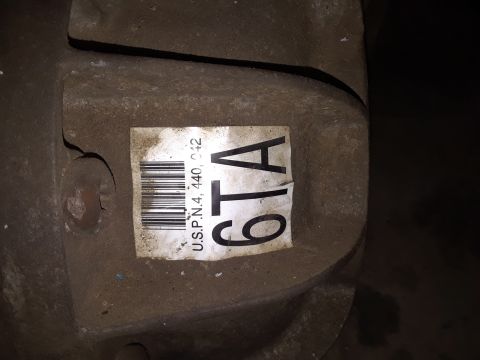 1996 Ford F-350 - A close-up of a vehicle's transfer case part with a label containing a barcode and part numbers.
