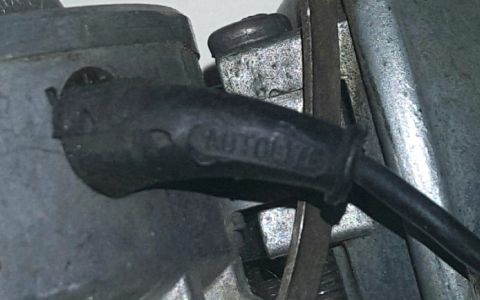 1973 Ford Mustang - Close-up of an Autolite spark plug wire boot, marked with '76'.