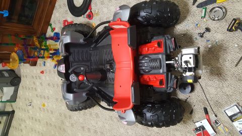 2007 Subaru Impreza - This toy ATV is upside down on the carpet, showing its interior and some disassembled parts.