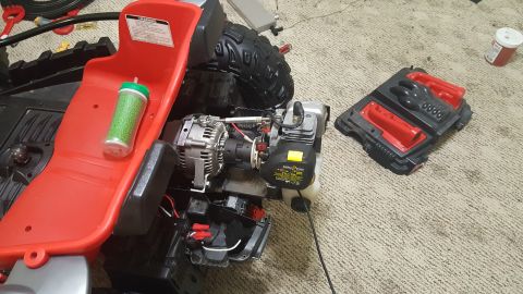 2007 Subaru Impreza - Disassembled toy vehicle engine and chassis components laid out on carpet. A green glitter cup sits on the red seat.