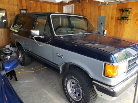 1989 Ford Bronco - This two-tone Ford Bronco is parked in a garage, displaying its front passenger side.