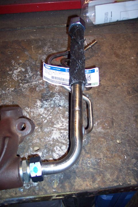 1995 Ford Bronco - A Ford engine part, possibly an oil cooler line, is shown with its protective wrap and a "Ford Parts" label.